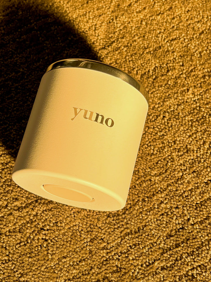 Yuno's refillable candle showcasing the bottom button